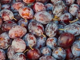 Whole ripe plums at a food market