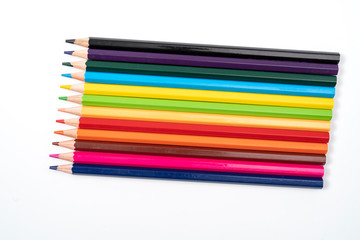 Colored pencils in a row isolated on white background.