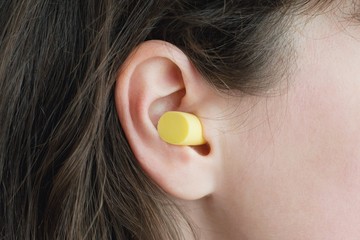 Woman's ear with an ear plug, noice  reduce, noice pollution .