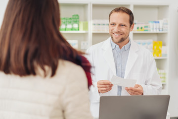Smiling male pharmacist assisting a woman