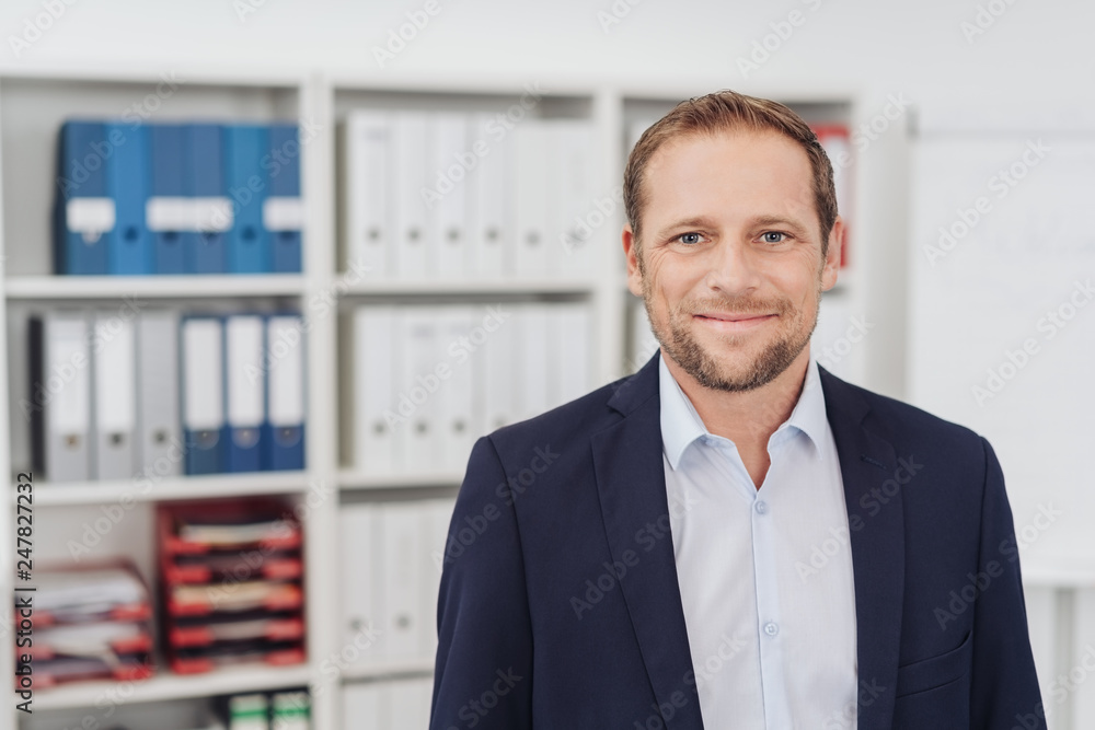 Wall mural portrait of modestly smiling adult man in office