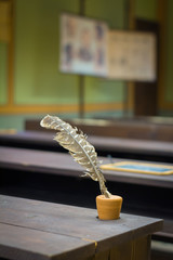 Quill and ink, old writing tool in vintage class room