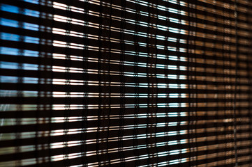 The interior of the home, sunlight shining through the bamboo blinds at the window.