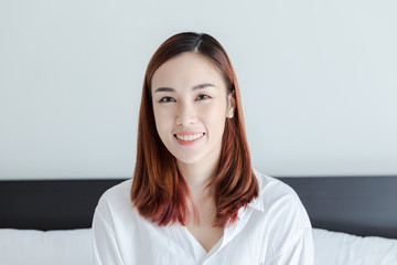 beautiful woman wear white shirt smile in bed room at the morning