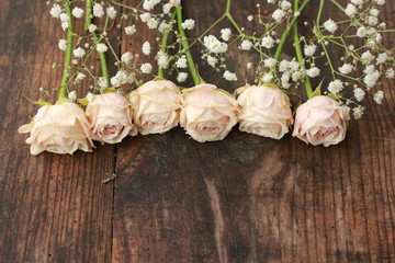 small pink roses on the wooden table