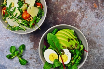Two fresh salads bowls isolated on dark background. Flat lay salad bowls