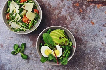 Two fresh salads bowls isolated on dark background. Flat lay salad bowls
