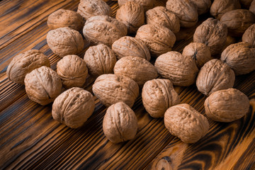 Close up many walnuts on a wooden table