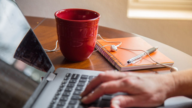 laptop sitting on table with coffee, notepad and earphones. good for writer, author, editor and creative mind