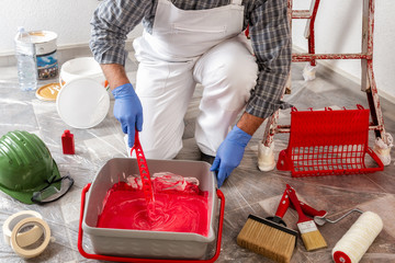 Professional house painter at work prepares the wall paint © francescomou