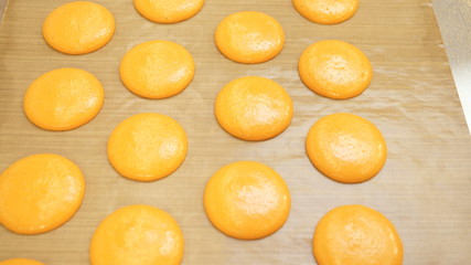 Ready-to-bake macaroons are on parchment for baking. Shadow of sunlight on parchment paper. Preparation for the holiday, preparation for Christmas, New Year, Valentine's Day