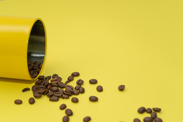 Coffee beans scattered from the yellow can