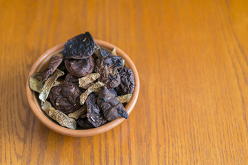 dried mushrooms boletus sliced, on a plate, on an old wooden background. Composition of dried mushrooms and plate on wooden background. opy space.