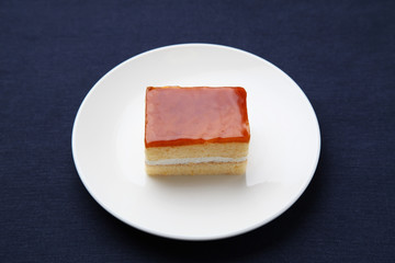 orange honey syrup cake on plate isolated on table