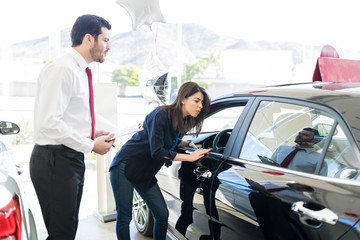 Customer Inspecting Automobile In Showroom