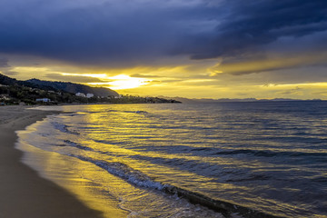 Beautiful colorful sunrise at the sea with dramatic clouds and sun shining