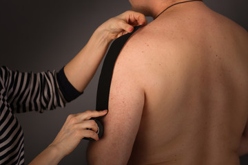 Fototapeta premium woman puts tapes on arm of ordinary man, Taping