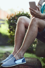 Modern man using cellphone outdoors.