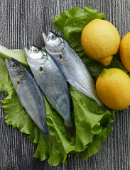 small bluefish and lemon, on wooden background