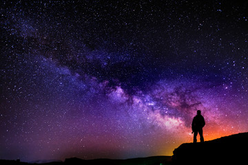 Naklejka na ściany i meble Beautiful starry night, man silhouette with a camera looking at the Milky Way galaxy.