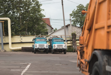 trash truck or dump-truck municipality sanitation salubrity truck fleet of city vehicles for urban garbage collector service with retro car transportation for sanitation services to city residents