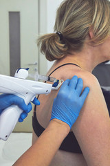 Female doctor doing mesotherapy treatment for shoulder pain. Beauty and healthcare.