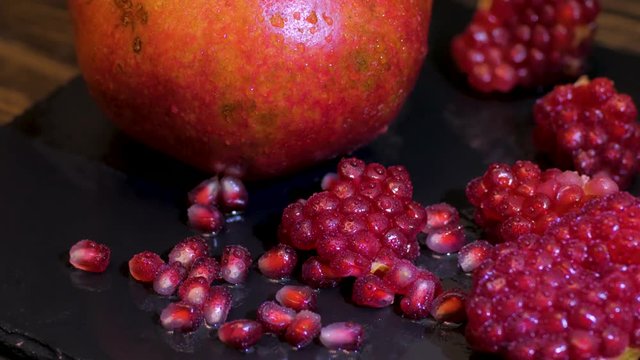Fresh colorful pomegranates fruits close up on black table 
