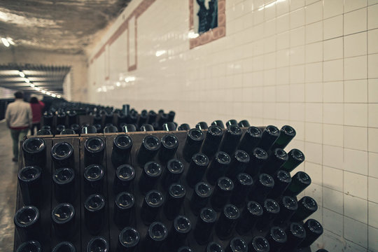 bottles of wine in the wine rack from the underground wine cellar for winery storage where winemaker keeps the wine production in the wineyard chateau wine vault