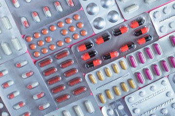 Pills in blisters on a pink background. Copy space for text
