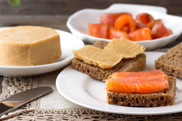Traditional Norwegian breakfast, sandwiches with brown cheese brunost, sandwiches with cucumber and trout.