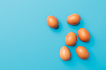brown eggs on blue turquoise background, top view