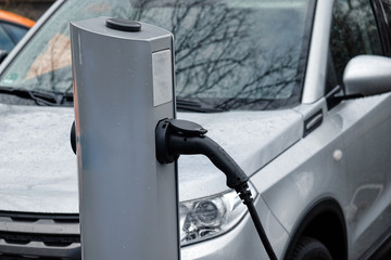 Power supply for electric car charging. Electric car charging station. Close up of the power supply plugged into an electric car being charged.