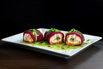 Salad with herring, beets, carrots, onions, potatoes and eggs on a plate.