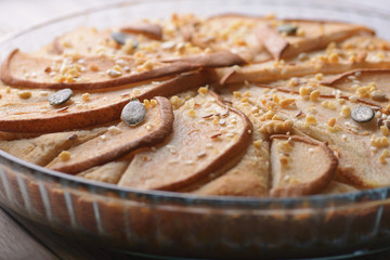 gorgeous pie with pears in a glass container on wooden background