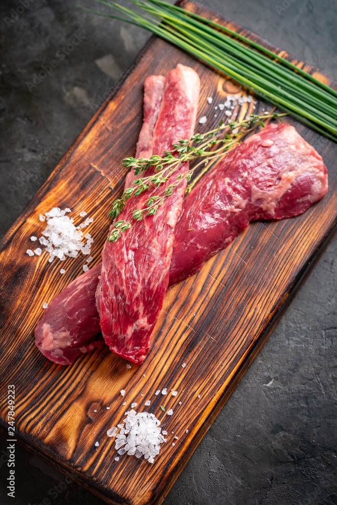 Wall mural two pieces of raw beef for grilling on a wooden board, flank steak premium beef, top view