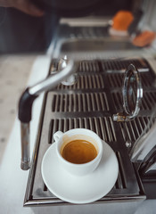 close-up view of glass cup with cappuccino and coffee machine