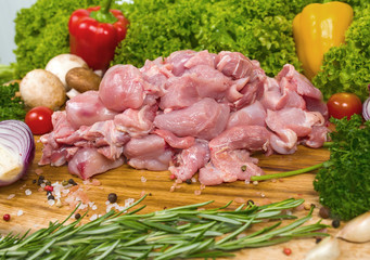 Raw lime rabbit on a wooden background with cherry tomatoes, lettuce leaves, garlic, chilli pepper, rosemary, onion