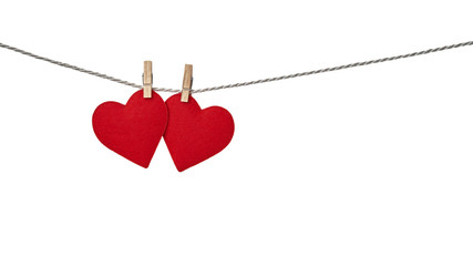 Two red felt valentine hearts hanging from a rope fixed by clothespins isolated on white background