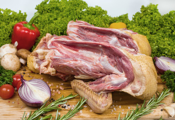 Two divided turkeys with a skin on a cutting wooden board with cherry tomatoes, lettuce, garlic, chilli, rosemary, onion. Preparation of a festive dinner