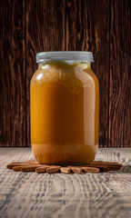 Glass pot full of honey on rustic wooden background