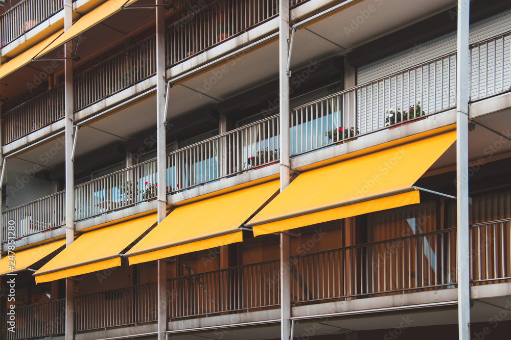 Wall mural Nice balcony with yellow awning in apartment house.