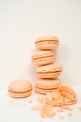 Peach macaroons, almond cookies with peach juice, lined in a column and next to one makroon bitten