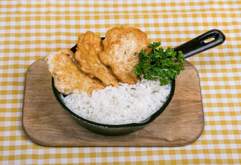 Chicken in batter with boiled rice, served in a frying pan with dill