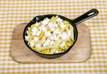 Macaroni pasta in American style with cheese sauce and crispy breadcrumbs, in a portioned saucepan