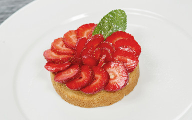 Delicious biscuit with fresh strawberries, mini cake with strawberries on a white plate