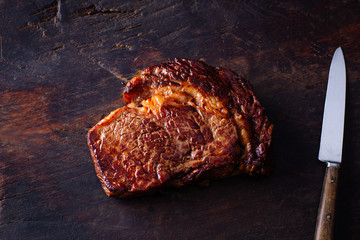 Close up of grilled beef steak on rustic wooden cutting board