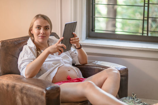 Pregnant Woman At Home Relaxing With IPad