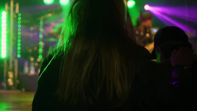 Rock concert in Germany. A fan with beautiful long hair dances at the stage of his favorite band.