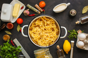 pasta, farfalle and sauce (set of ingredients). food background. copy space