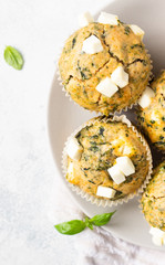 Freshly baked muffins with spinach and feta cheese. Light background. Copy space.